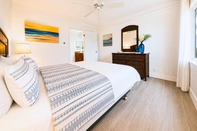 Primary bedroom at Napili Point B31 — warm wood furnishings and coastal artwork create a relaxed island retreat
