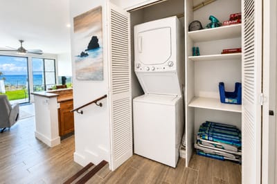 In-unit laundry at Napili Point B31 — stacked washer and dryer plus beach gear storage for effortless island stays
