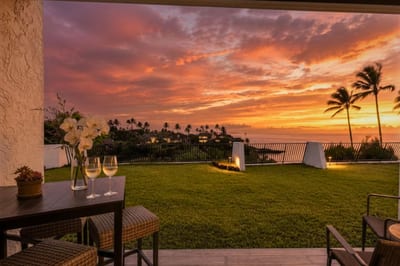 Sunset lanai at Napili Point B31 — private patio seating framed by a blazing Maui sky, perfect for evening wine and ocean air