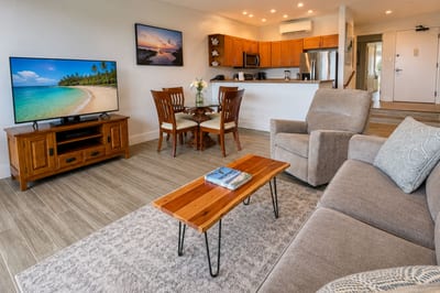 Great room at Napili Point B31 — comfortable sofa seating, smart TV, and a kitchen that opens onto sweeping island views