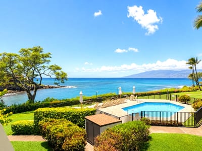Gated oceanfront pool area surrounded by vibrant greenery