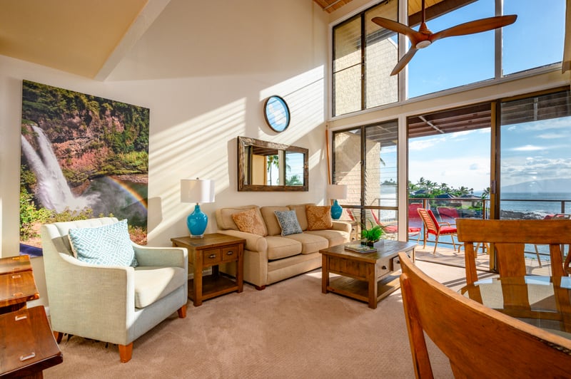 Vaulted ceilings, ocean views, and warm island tones create a living room that feels both grand and grounding NAP-C18