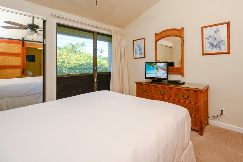 Garden-view guest room with cozy linens, tropical art, wood textures, and a stylish touch of island elegance NAP-C18