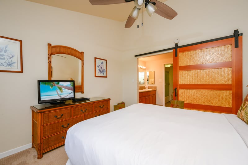 Cozy guest room with tropical wood furnishings, sliding barn door, garden views, and soft ambient lighting NAP-C18