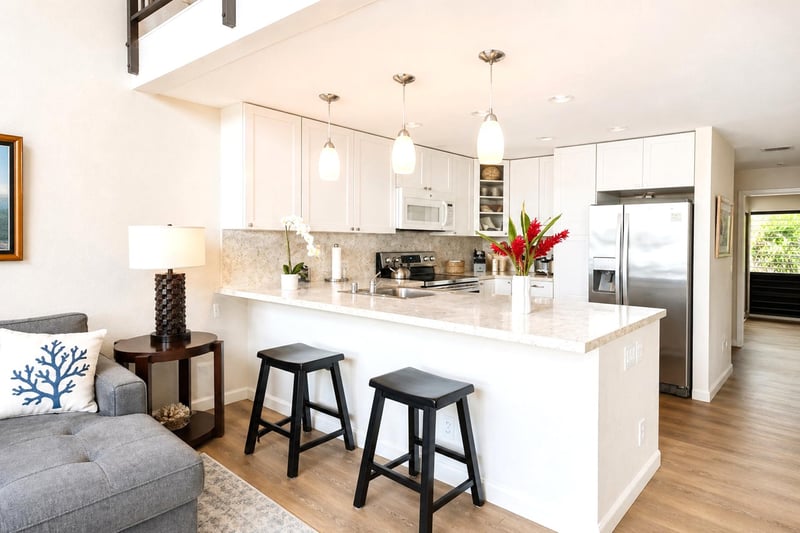 The kitchen features white cabinetry, bar seating, and plenty of counter space for cooking prep NAP-C19