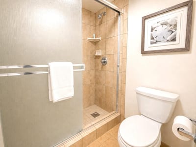 The guest bathroom features a walk in shower and elegant tile finishes