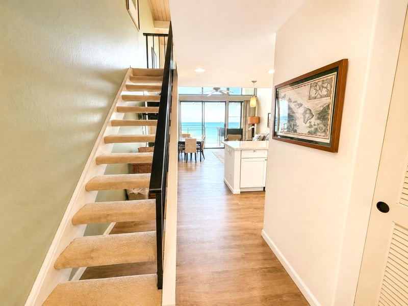 A light-filled interior space with a charming staircase and warm wood tones NAP-C19