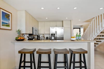 Bright and open, this modern kitchen boasts sleek stone countertops, stainless appliances, and a breezy layout