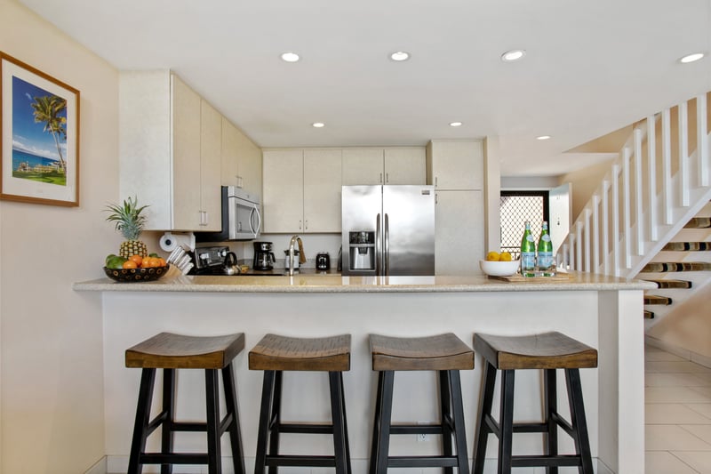 Bright and open, this modern kitchen boasts sleek stone countertops, stainless appliances, and a breezy layout