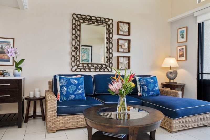 Island chic meets comfort in this airy space with navy cushions, woven textures, and open lofted serenity