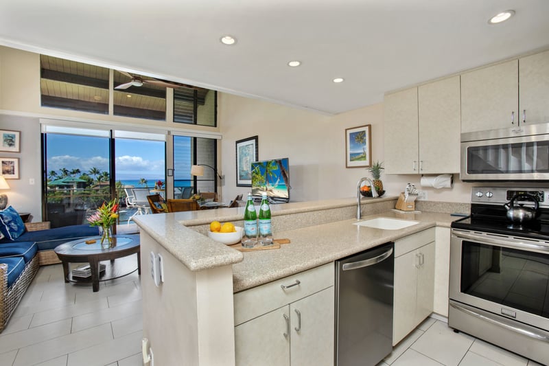 This open kitchen features a spacious island, full-size fridge, and clean cabinetry for effortless island-style living
