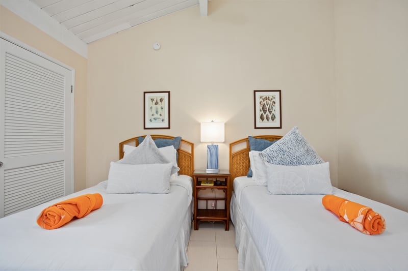 Chic twin suite with natural light, soft tones, wood accents, and a tranquil vibe for a rejuvenating island stay