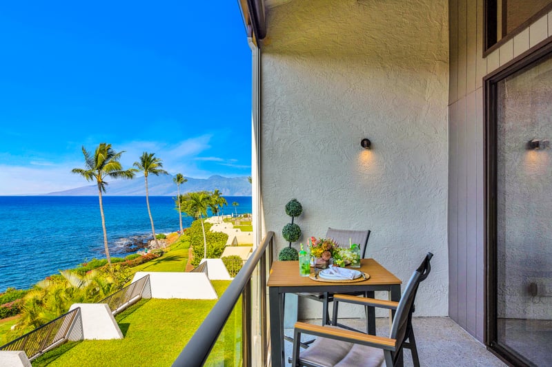 Your private lanai entry offers an inviting outdoor corner, ideal for morning coffee with garden greens and ocean blues nearby.