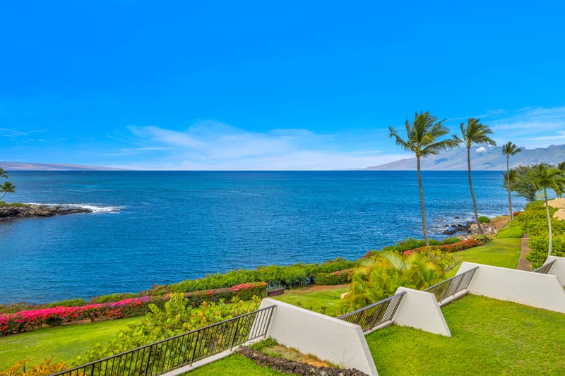 Oceanfront lawn and lava rock shoreline set the scene at Napili Point, with wide Pacific views that make every stroll feel unforgettable.