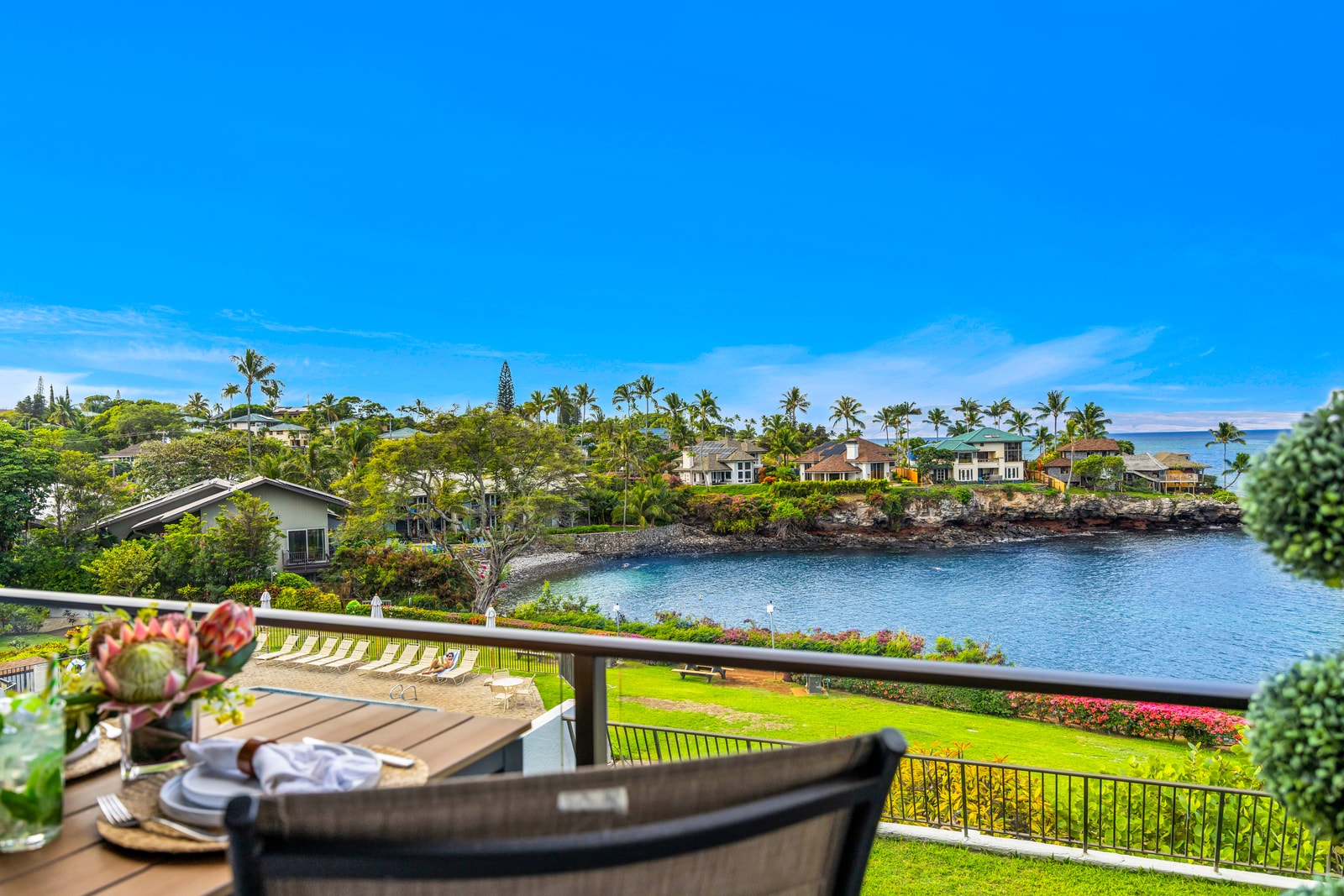 Enjoy an easy outdoor setup on the lanai with ocean views framed by tropical landscaping and the sound of the surf nearby. NAP-C32