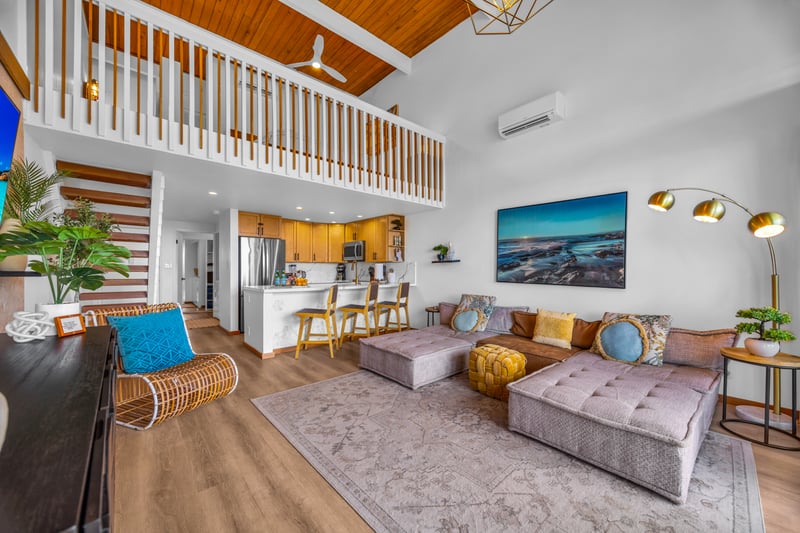 This angle highlights the soaring ceilings and loft railing, giving the main living space a breezy, spacious feel.