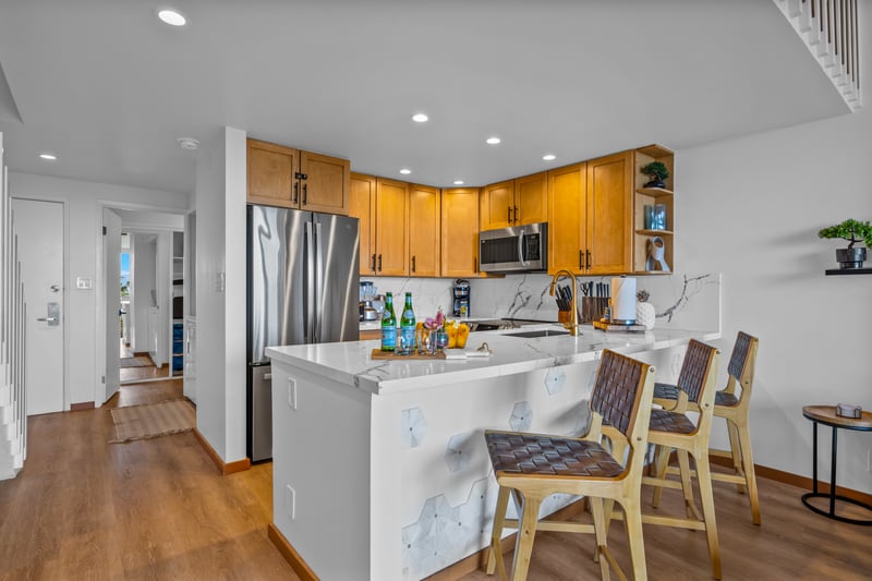 Cook with ease in the open kitchen with wood cabinetry, stainless appliances, and a roomy island that keeps prep simple.