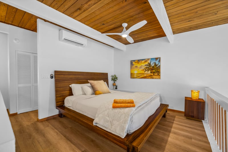 Guest bedroom comfort meets island style, with vaulted wood ceiling details that make the room feel open and airy.