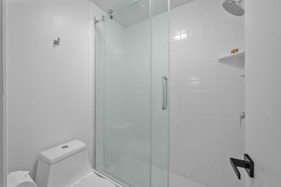 Step into the guest bath with a glass shower enclosure and clean, modern look for a quick refresh anytime.