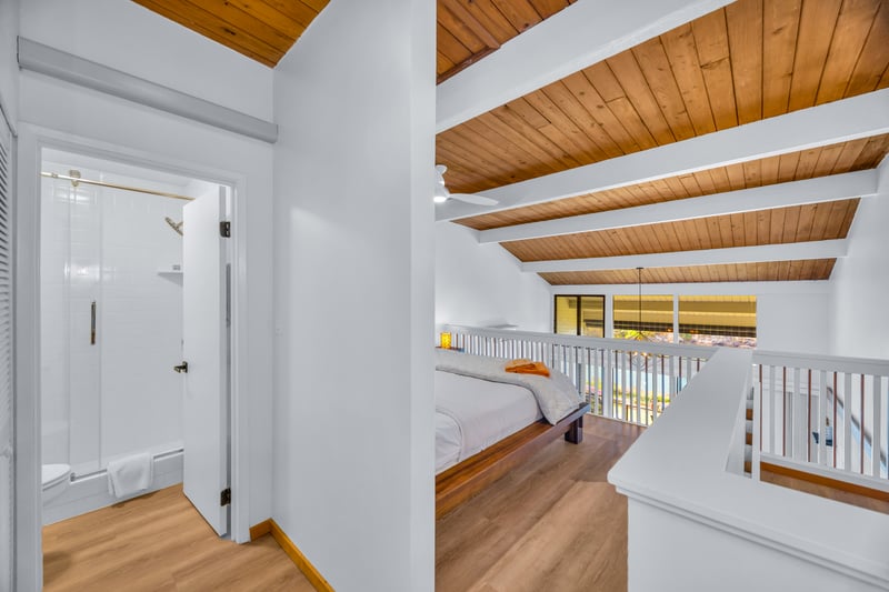 The guest room setup stays light and airy under the wood ceiling, a peaceful spot for afternoon downtime.