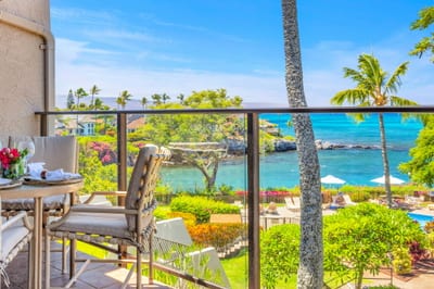 Oceanfront lanai with outdoor dining and panoramic views of turquoise waters, lush gardens, and the pool below — perfect for a tropical escape. NAP-C37