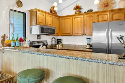 Fully equipped kitchen with granite countertops and stainless steel appliances—perfect for home-cooked island meals. NAP-C37