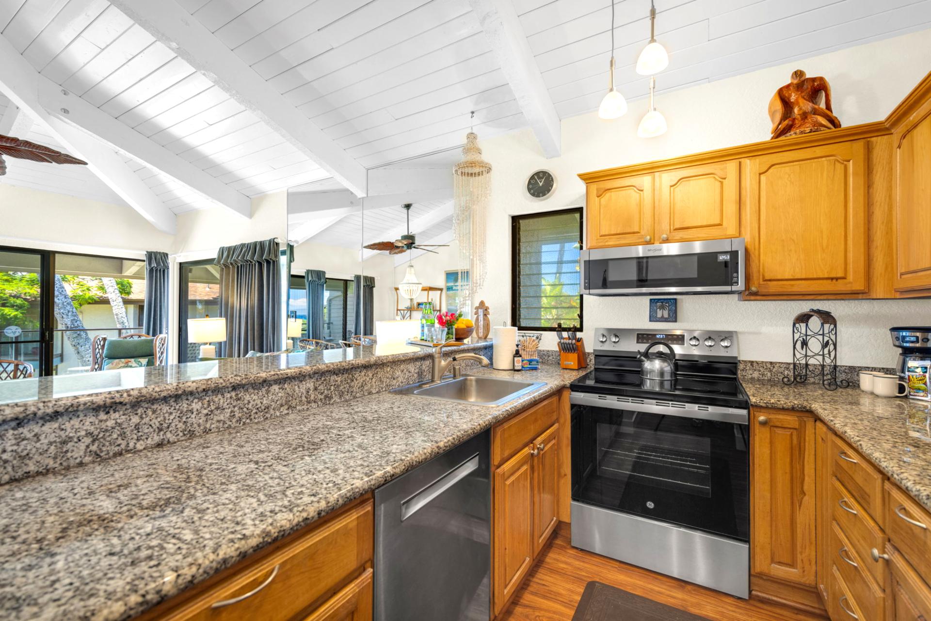 Bright, open kitchen with granite counters and a view of the ocean—cooking has never felt this relaxing. NAP-C37