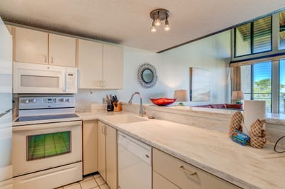 Bright kitchen with marble countertops, modern lighting, and scenic views. NAP-C42