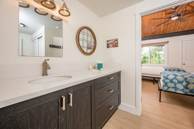 A sleek vanity with dark wood cabinetry and matte bronze fixtures brings warmth and contrast to this serene master bath