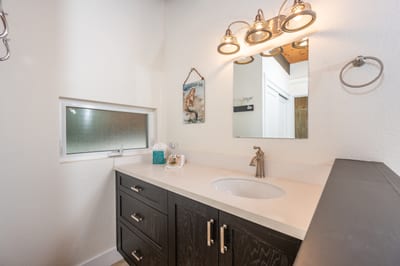 Under a trio of vintage-inspired sconces, the space glows with soft light—perfect for quiet morning or evening rituals