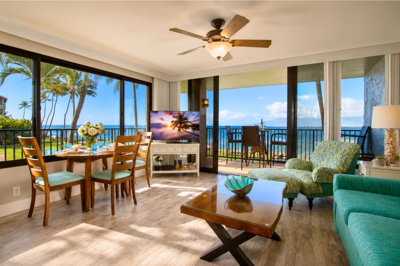 Open-concept living area with ocean views, full-length windows, and direct lanai access for seamless indoor-outdoor flow.