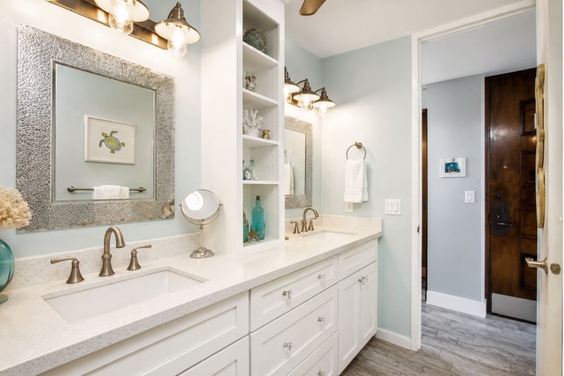 Dual-sink vanity with granite counters and spa-style lighting offers ample space for getting ready.
