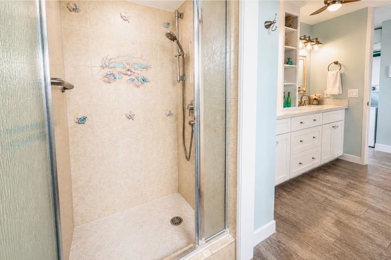 Walk-in shower with frosted glass door and natural stone floor for a clean, modern refresh.