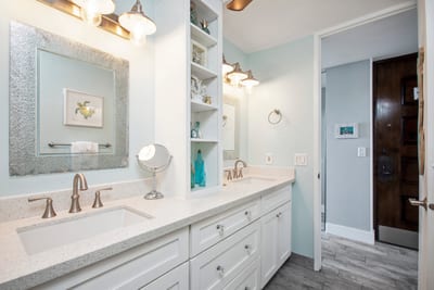 Dual-sink vanity with granite counters and spa-style lighting offers ample space for two.