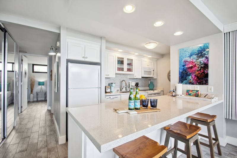Light-filled kitchen with updated appliances and a breakfast bar, perfect for preparing easy vacation meals.