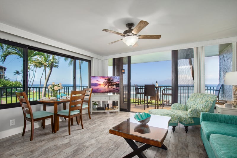 Open-concept living area with ocean views, full-length windows, and direct lanai access for seamless indoor-outdoor flow.