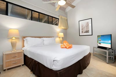 A peaceful guest room with golden touches and a king bed that promises restful nights and island ease