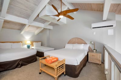 A dreamy loft retreat with vaulted beams and three cozy beds—perfect for families or group getaways