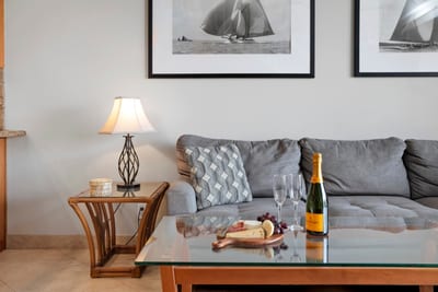 Toast to island evenings on a plush gray sofa, where nautical art and a sparkling bottle set the mood just right