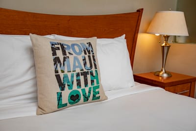 Crisp white linens and airy beams give this guest bed the feel of a tucked-away tropical treehouse
