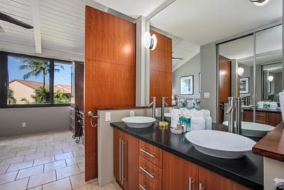 Thoughtfully designed with dual vanities, warm tile flooring, and glowing lighting for a relaxed, spa-like atmosphere