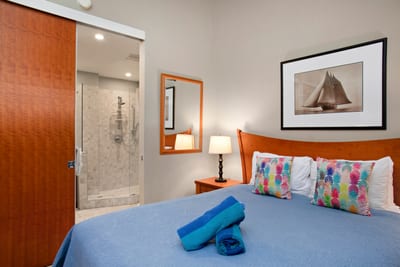 This guest bedroom balances bright island accents with simple elegance and a plush, welcoming bed