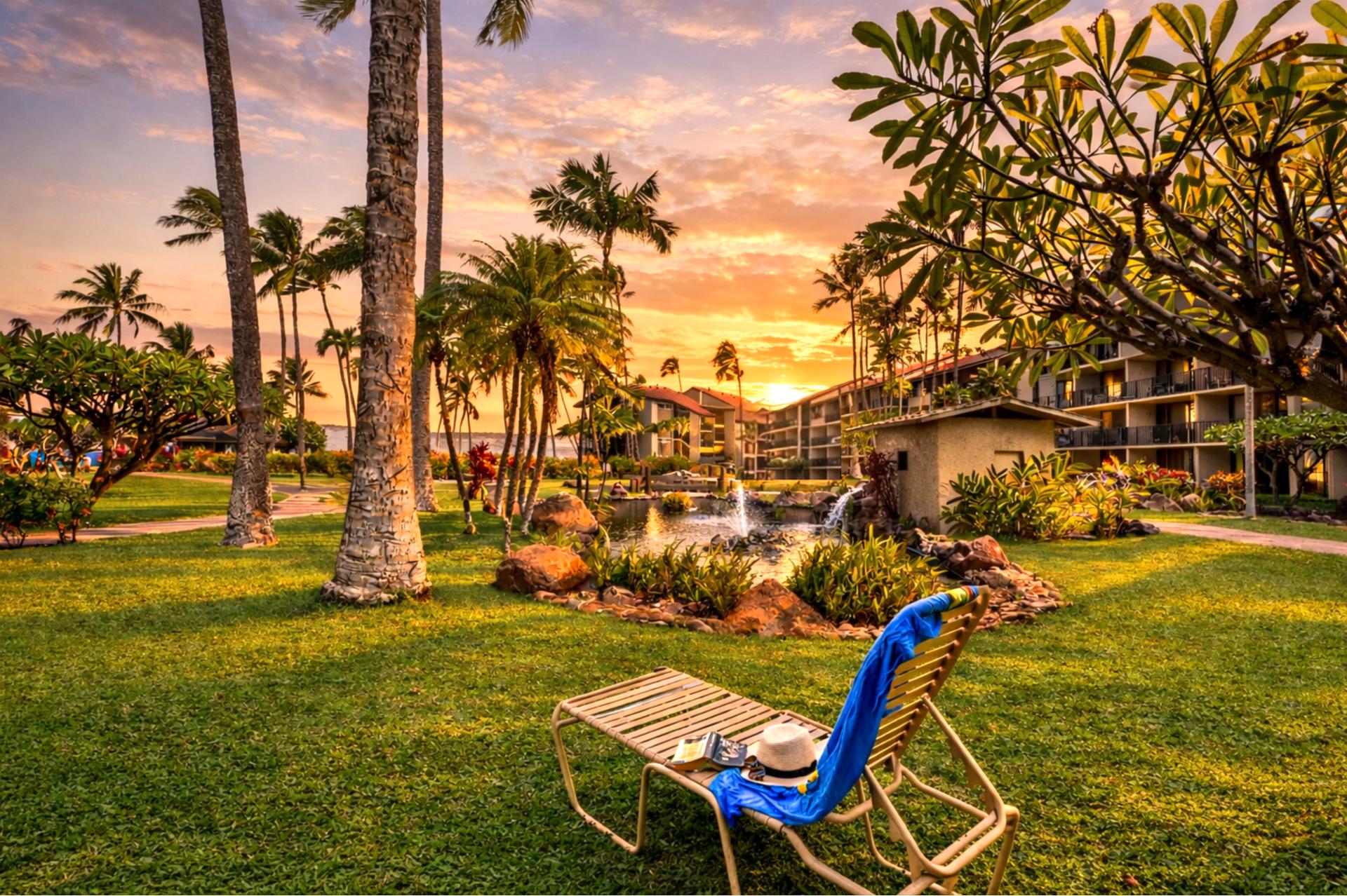 Golden hour settles over Papakea’s beachfront grounds, where you can stroll across manicured lawns toward the ocean as the sky glows in warm island light.
