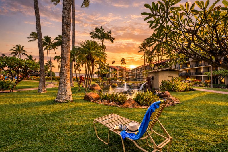 Golden hour settles over Papakea’s beachfront grounds, where you can stroll across manicured lawns toward the ocean as the sky glows in warm island light. PKD-104