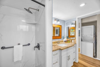 The bath features a marble walk-in shower with rainfall shower head