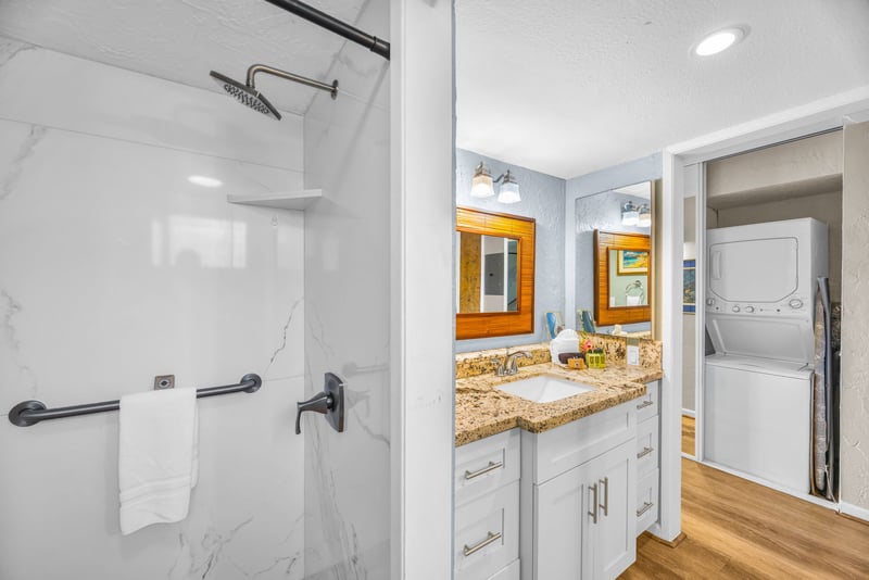 The bath features a marble walk-in shower with rainfall shower head
