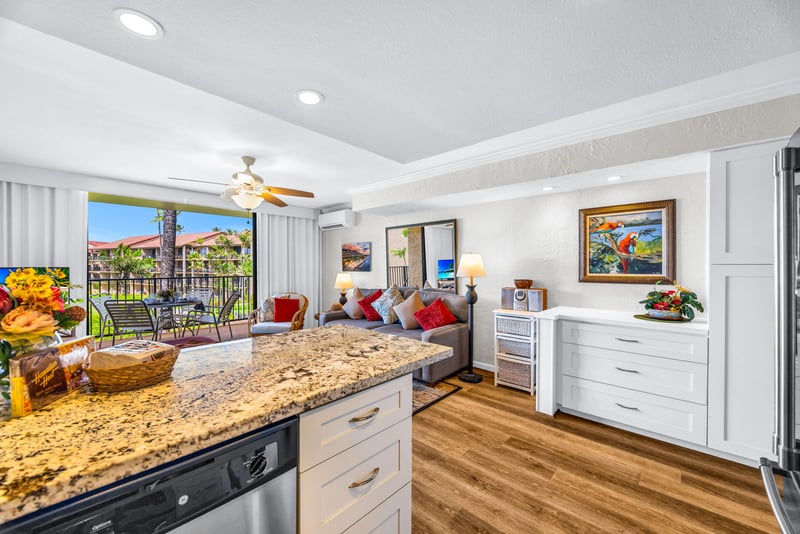 Granite countertops and stainless appliances with the lanai visible beyond the breakfast bar