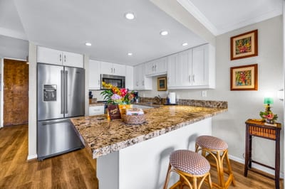 The kitchen features a breakfast bar with two stools for convenient seating