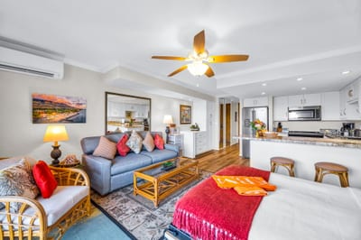 The living area opens toward the lanai with a comfortable sofa and rattan accents