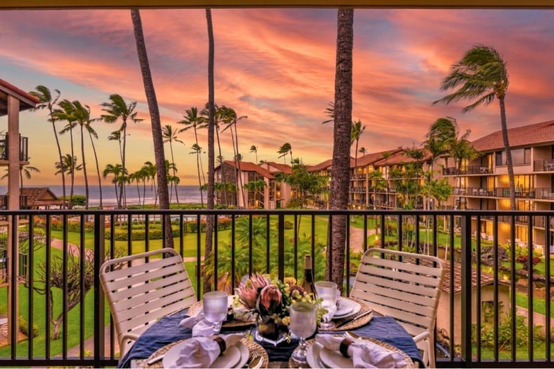 The covered lanai is set for outdoor dining with ocean views, perfect for a nightcap while watching the sunset.